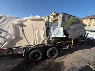 Junk Busters trailer fully loaded with furniture and mattresses on a Corpus Christi job